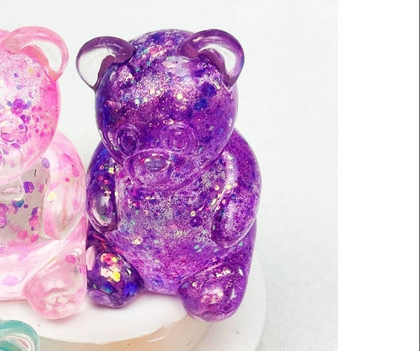 Purple gummy bear figurines on a white background